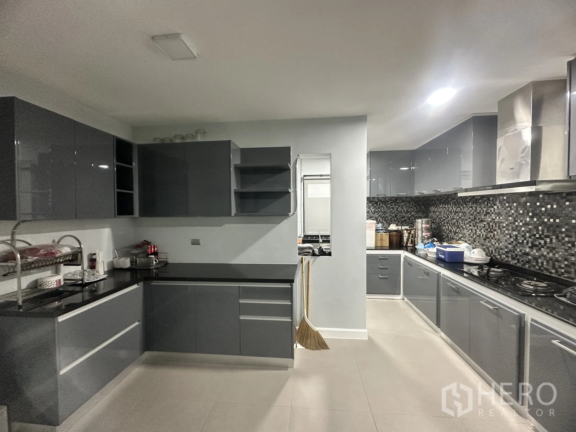 Detached House for sale in Pak Kret, Nonthaburi - Large kitchen with glossy cabinets, gas hobs, and mosaic tile backsplash.
