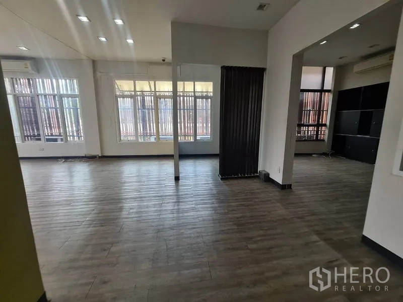 零售空间 出租在Watthana, Bangkok - 开阔营业区，宽窗、置物柜与黑色屏风。