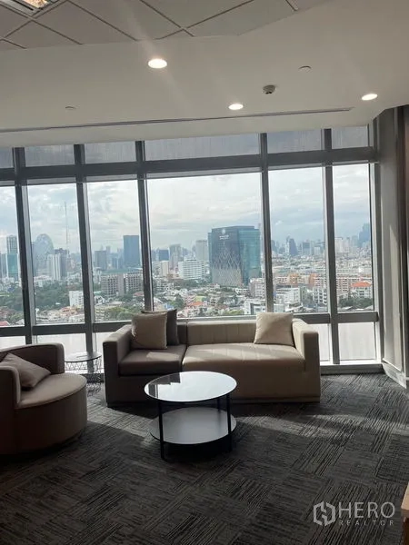 Office Space for rent in Dusit, Bangkok - Comfortable sofa corner with round coffee table and dramatic city panorama.