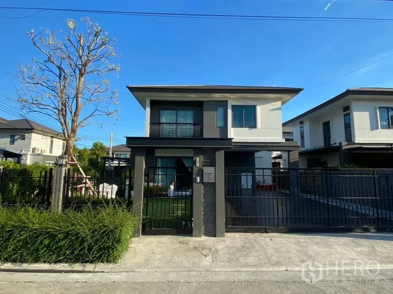 Detached House for rent in Bang Phli, Samut Prakan - Front facade of the two‑storey detached house behind a black metal fence.