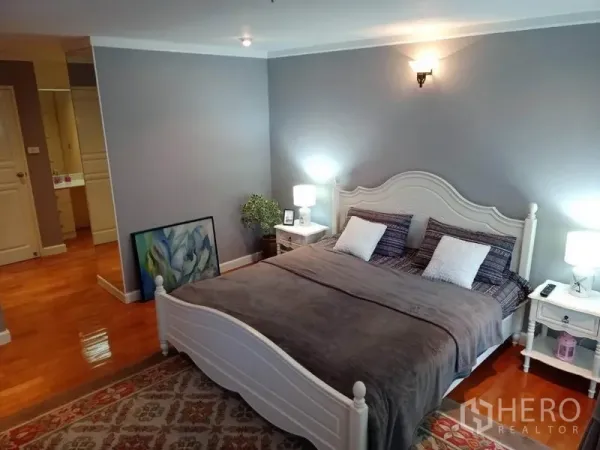 คอนโด ให้เช่าหรือขายในWatthana, Bangkok - ห้องนอนใหญ่กว้าง เตียงสีขาว ผนังสีเทา และโคมไฟข้างเตียง