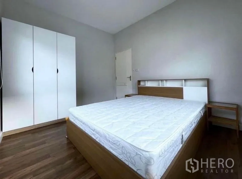 Detached House for rent in Prawet, Bangkok - Guest bedroom with queen bed, wardrobe, wood floors and twin windows with blinds.