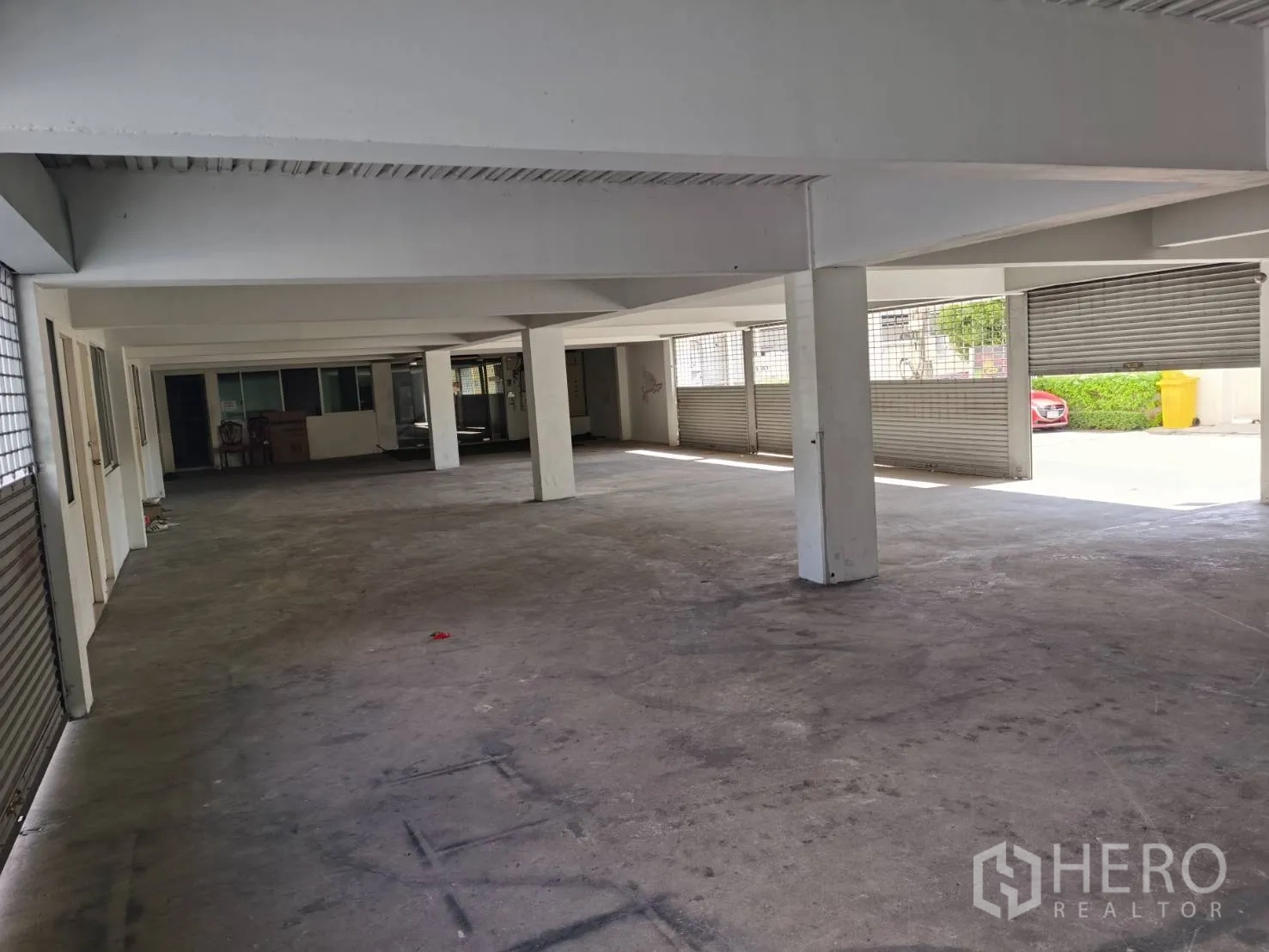 สำนักงานที่บ้าน ให้เช่าหรือขายในHuai Khwang, Bangkok - ที่จอดรถชั้นล่างในอาคาร พื้นคอนกรีต พร้อมประตูม้วน