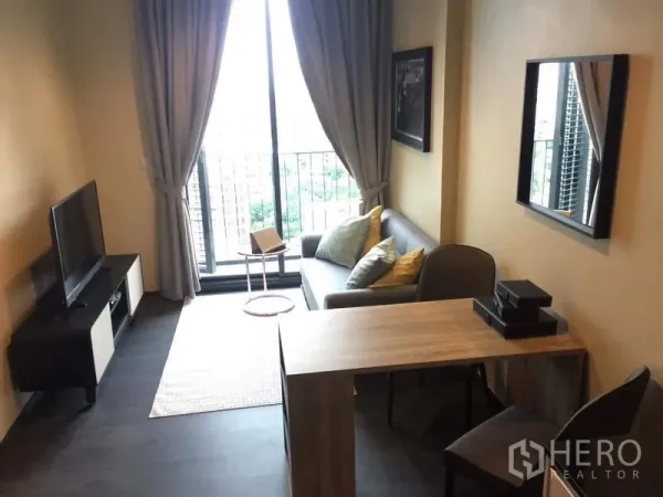 คอนโด ให้เช่าในWatthana, Bangkok - มุมมองห้องนั่งเล่นไปยังระเบียง พร้อมชั้นทีวีและพรมพื้นที่