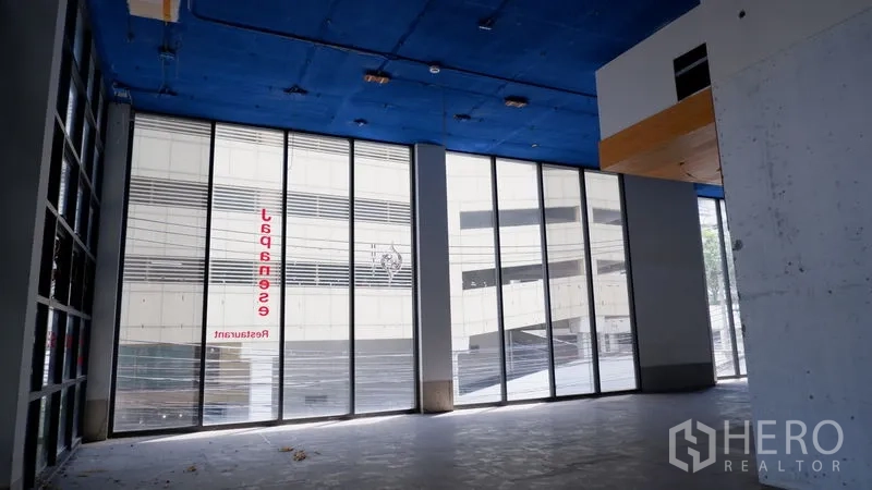 零售空间 出租在Watthana, Bangkok - 转角落地玻璃立面，高挑空间，面向街景。