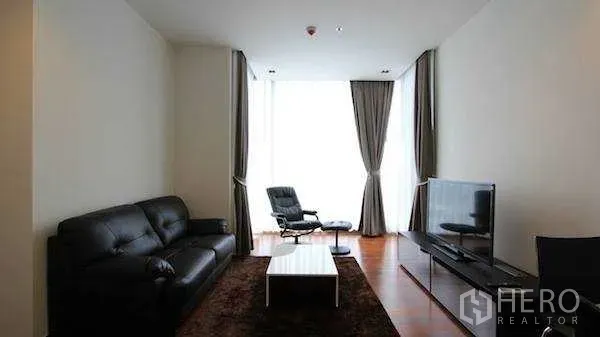 Condominium for rent - Cozy lounge with leather sofa, TV and full‑height curtains in a high‑rise condo.