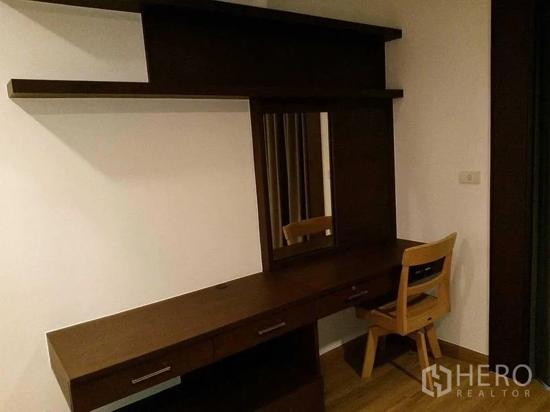 Condominium for rent in Sathon, Bangkok - Workstation with long vanity desk, mirror, drawers, and wooden chair.