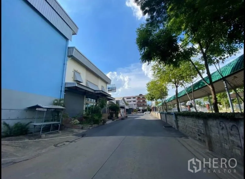 货栈 出租在Sai Mai, Bangkok - 仓库临街正面，旁有带顶步行廊与周边低层建筑。