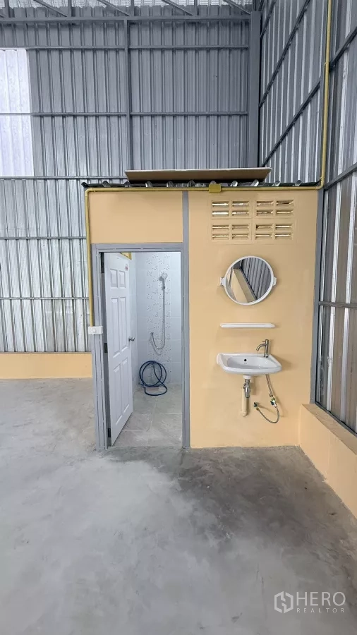Warehouse for rent in Wang Thonglang, Bangkok - Internal restroom block with sink and mirror located within the warehouse.