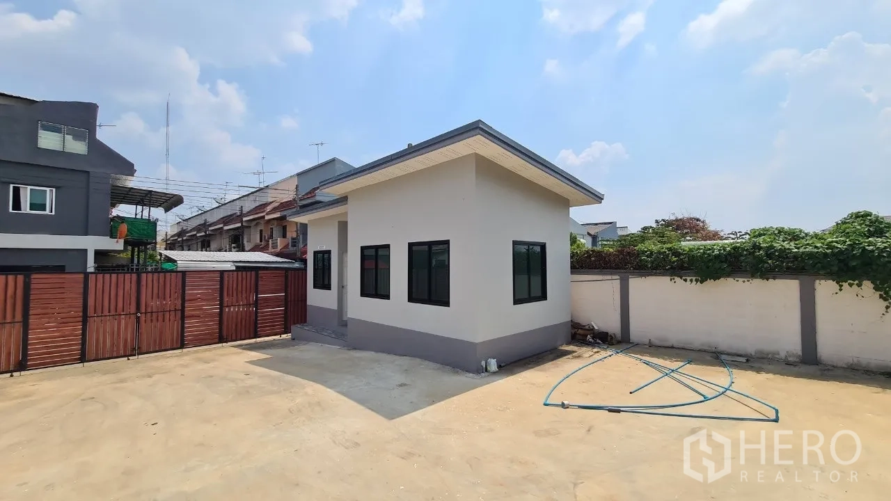 Home Office for rent in Pathum Thani - Detached single-storey outbuilding inside a gated compound with paved yard.