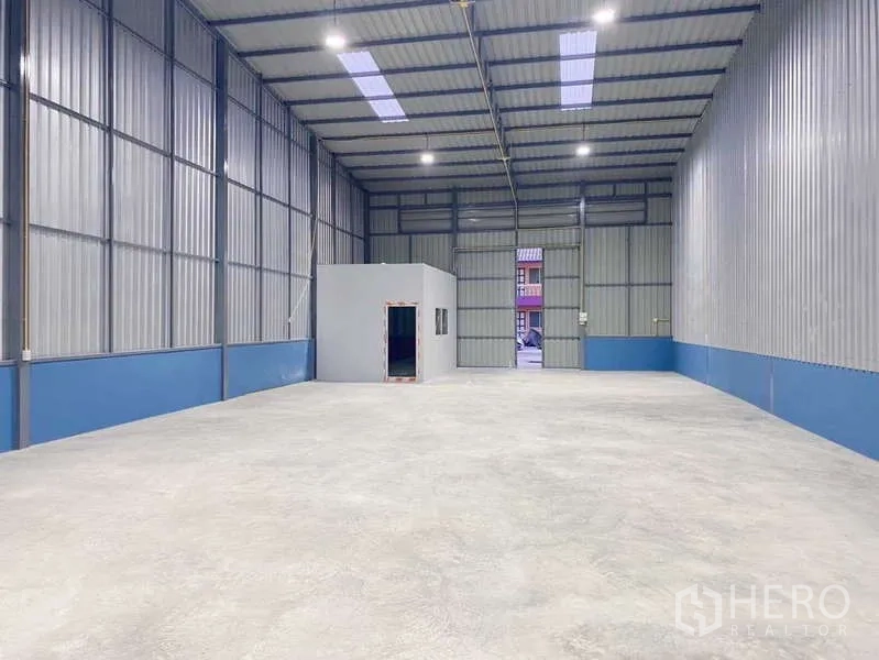 Warehouse for rent in Pak Kret, Nonthaburi - Spacious 300 sqm storage bay with an internal office box and tall roller shutter entry.