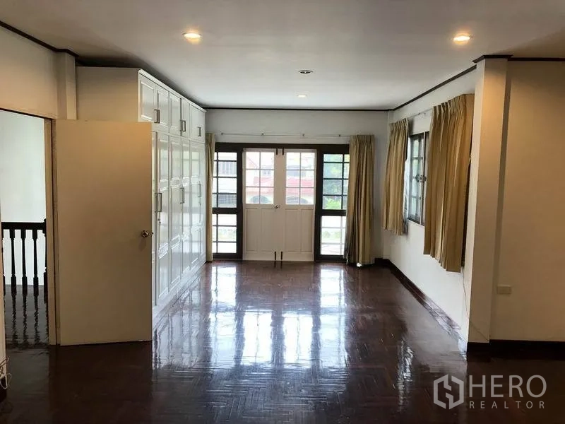 Detached House for rent - Master bedroom with a wall of white cabinets and balcony-style double doors.