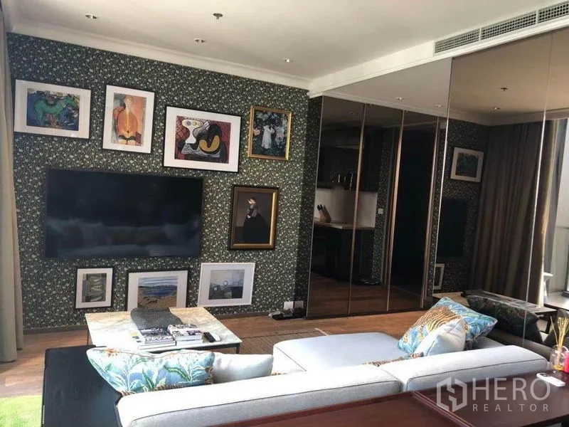 คอนโด ให้เช่าในPathum Wan, Bangkok - มุมพักผ่อนติดทีวีจอใหญ่ กรอบภาพ และตู้เสื้อผ้ากระจกเงา