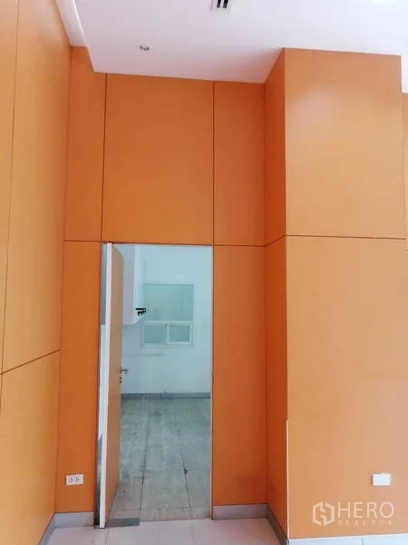 办公空间 出租在Pathum Wan, Bangkok - 室内橙色墙面板，通往后勤办公区的门。