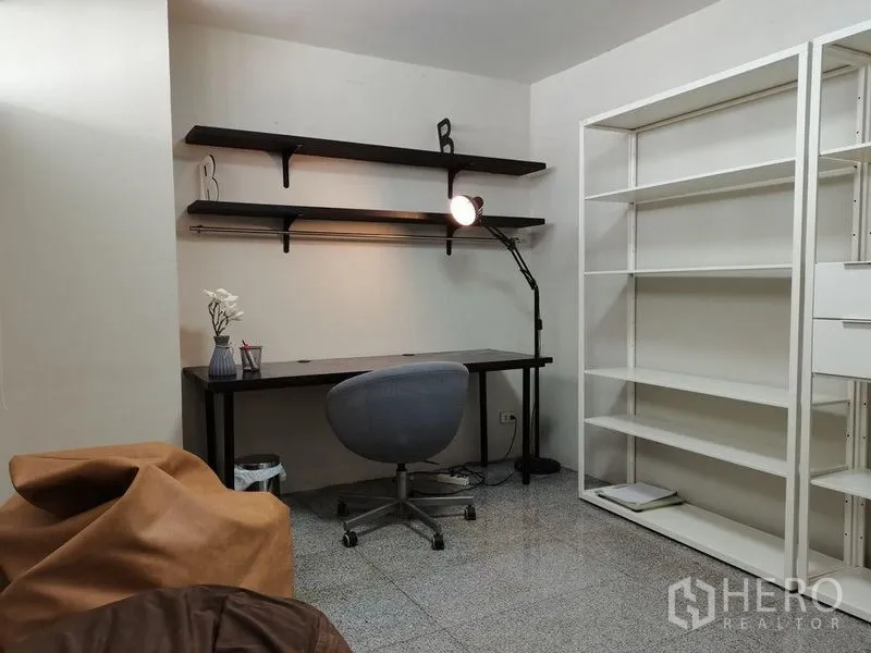 公寓 出租在Khlong Toei, Bangkok - 安静的书房，长书桌、工作灯、壁挂层板与白色书架。