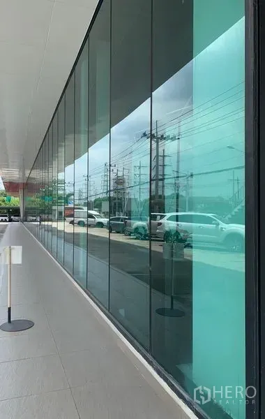 Retail Space for rent in Lam Luk Ka, Pathum Thani - Modern glass façade along a main road providing high visibility for retail signage.