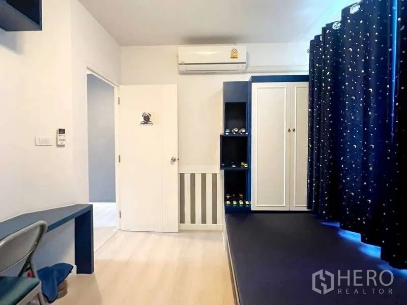 独立式住宅 出租在Bang Phli, Samut Prakan - 次卧带平台床、蓝色一体柜、衣柜与空调。