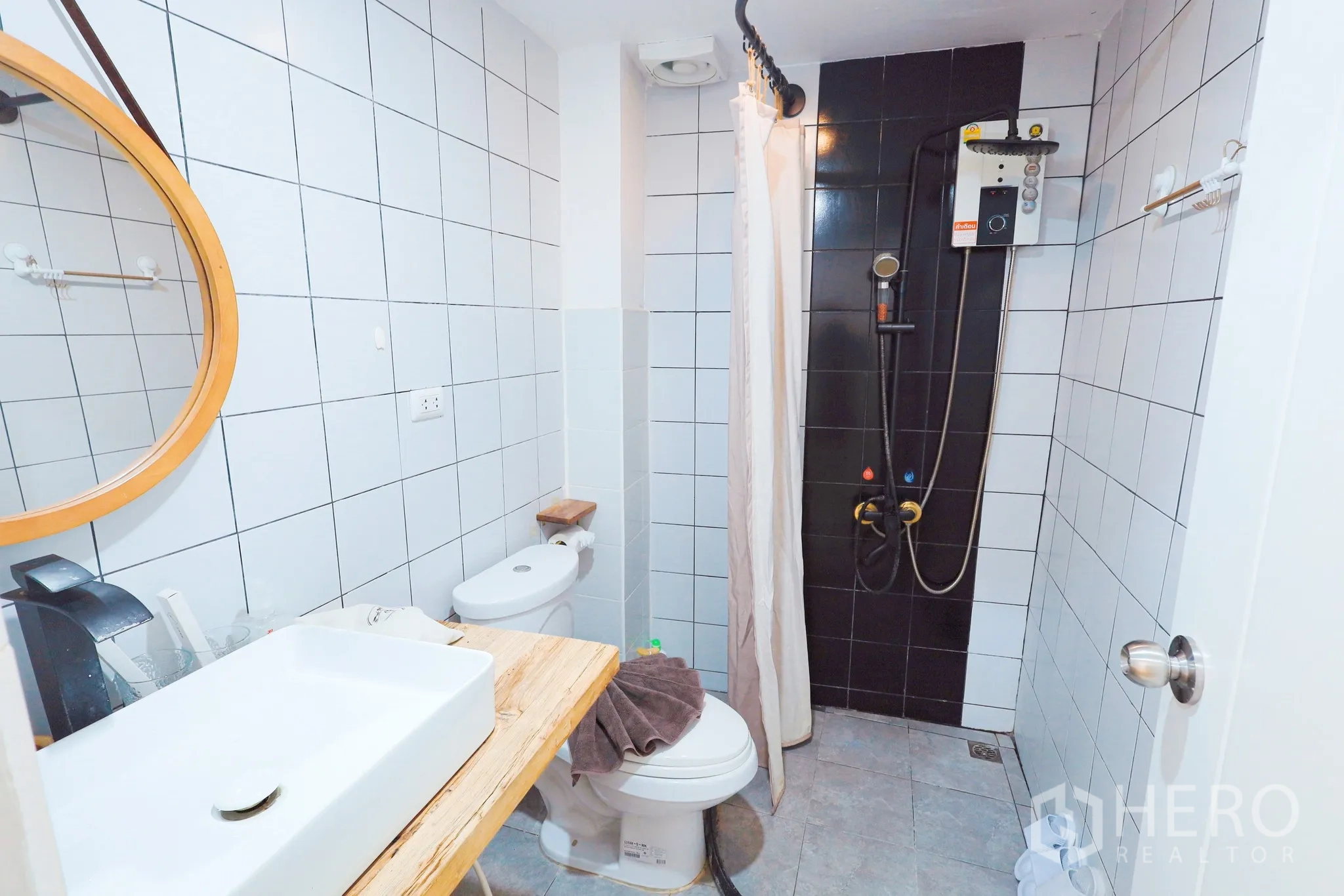 Townhouse for rent in Din Daeng, Bangkok - Tiled bathroom with vanity, toilet and walk-in shower with water heater.