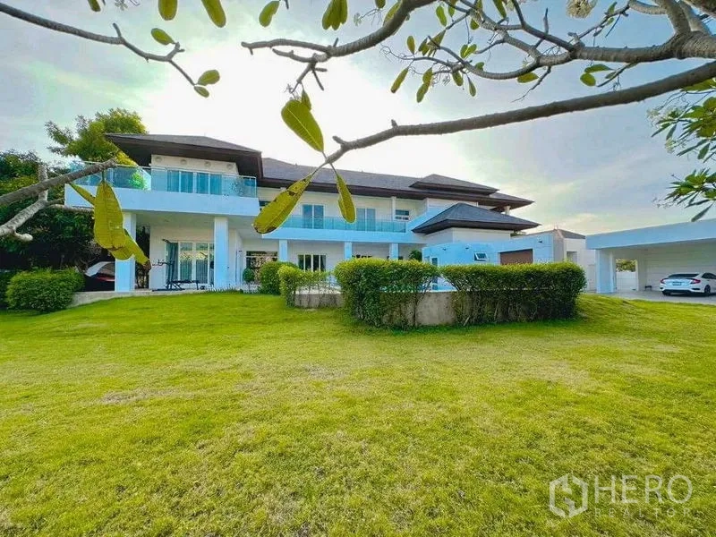 Detached House for rent or sale in Bang Phli, Samut Prakan - Wide green front yard leading to a two‑storey home and carport