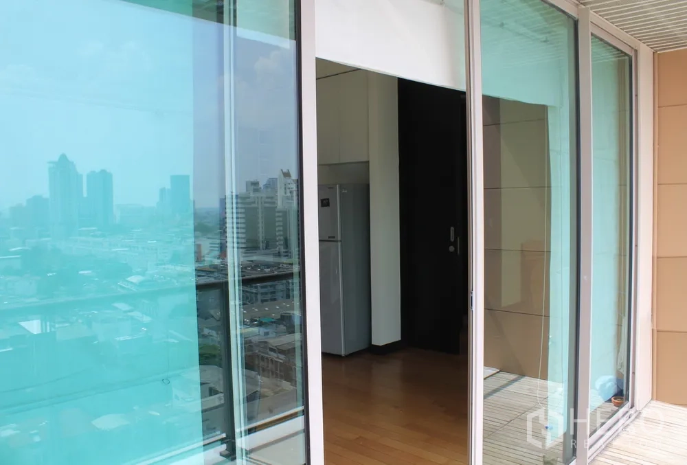 Condominium for rent or sale in Yan Nawa, Bangkok - Sliding glass doors from the balcony into the unit with city view and a kitchenette with fridge inside.