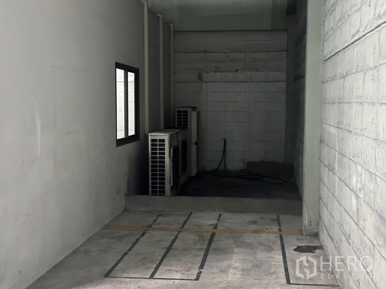 Warehouse for rent in Bang Na, Bangkok - Narrow service bay housing outdoor AC compressor units.