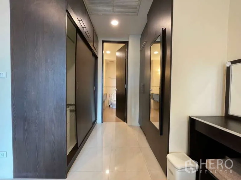 房间 出租在Khlong Toei, Bangkok - 走廊式衣帽区，推拉门衣柜通往浴室