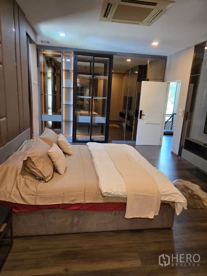 Detached House for rent or sale in Bang Phli, Samut Prakan - Primary bedroom alternate view showing mirrored closets and access to a balcony.