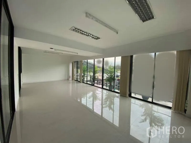 Office Space for rent in Suan Luang, Bangkok - Office lounge with floor-to-ceiling windows opening to a terrace with plants.