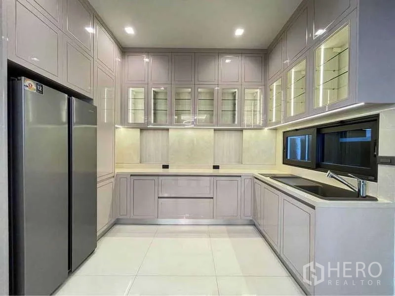 Detached House for rent in Bang Sue, Bangkok - Modern built-in kitchen with glass-front cabinets and twin-door fridge.