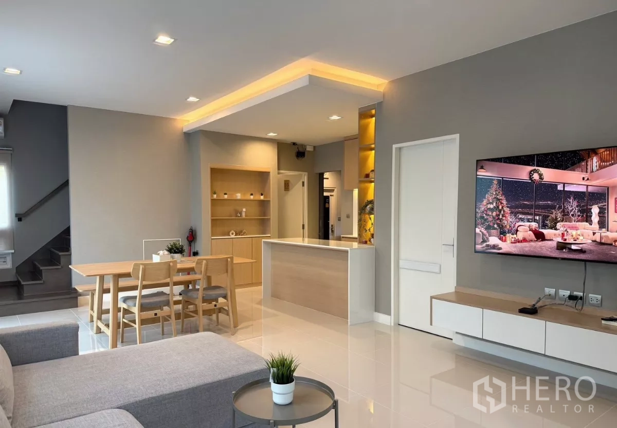 Detached House for rent in Prawet, Bangkok - Open-plan living and dining area with kitchen island and wall-mounted TV
