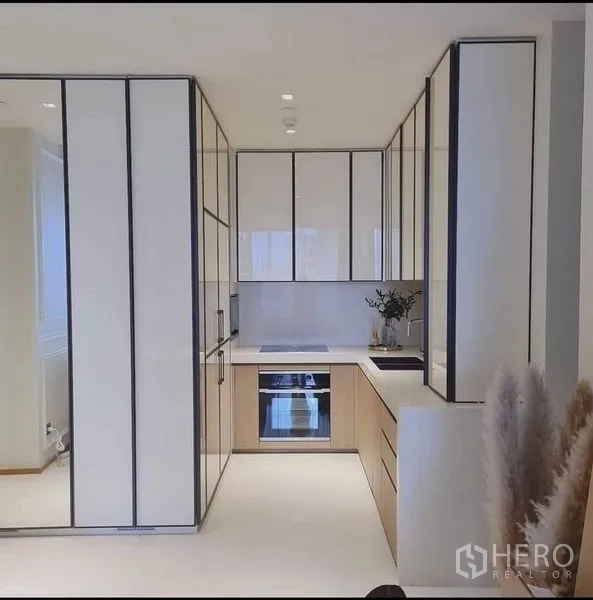 คอนโด ขายในKhlong Toei, Bangkok - ครัวรูปตัว U โทนขาว ตู้บิลท์อิน เตาอบ และเตาอินดักชัน