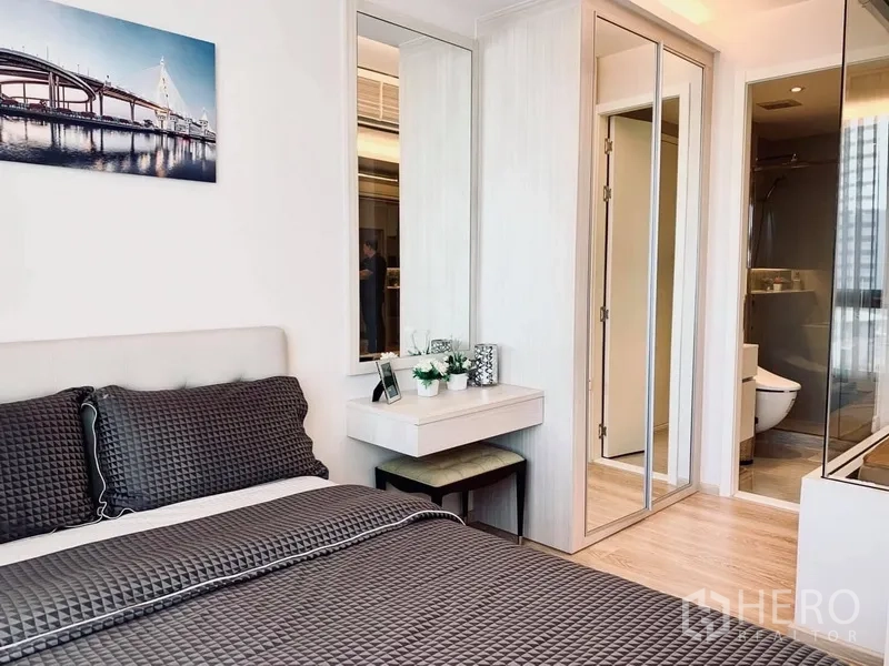 Condominium for rent in Watthana, Bangkok - Cozy bedroom with gray bedding, built‑in wardrobe, vanity, and ensuite bathroom.