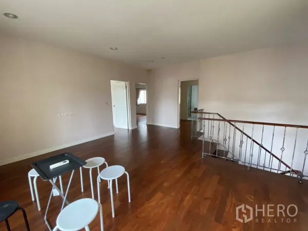 บ้าน ให้เช่าหรือขายในLak Si, Bangkok - โถงชั้นบน พื้นไม้ขัดมัน ประตูสีขาว และราวบันไดโลหะ.