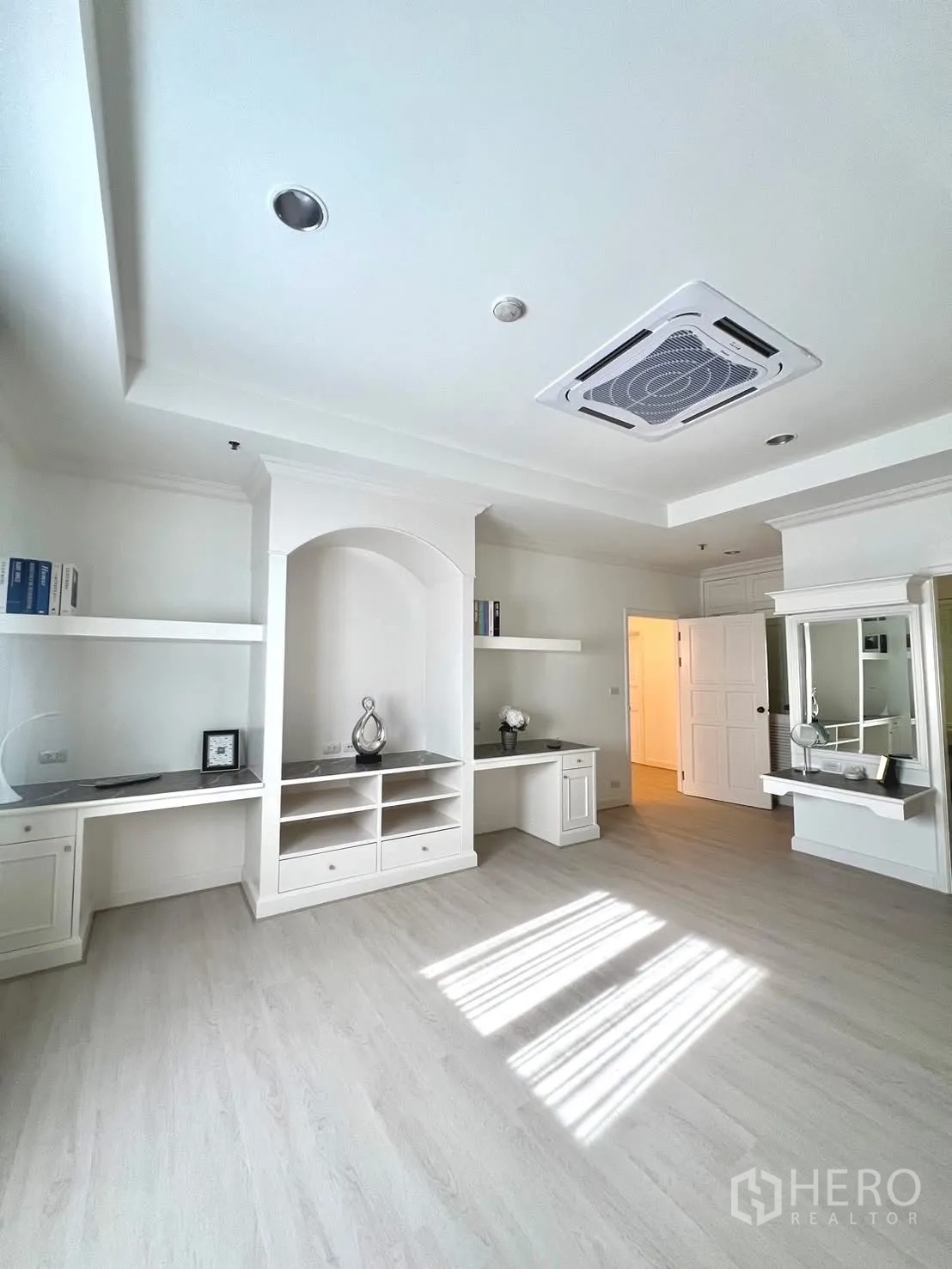 Condominium for rent in Khlong Toei, Bangkok - Room featuring multiple built-in desks and shelves with light flooring.