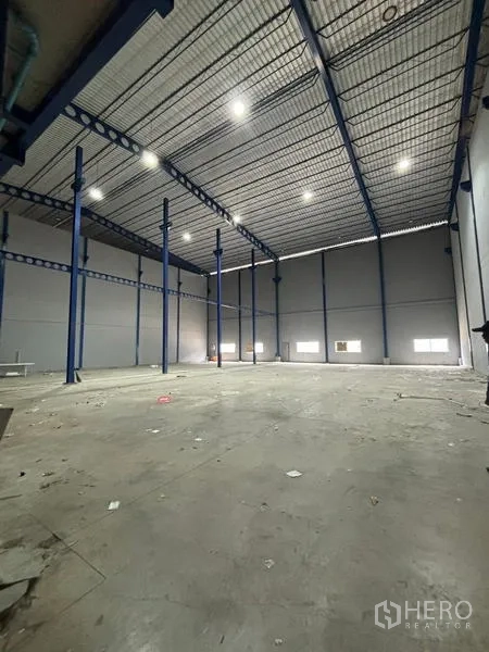 Warehouse for rent in Krathum Baen, Samut Sakhon - Spacious high-bay warehouse interior with steel columns, insulated roof and bright LED lights.