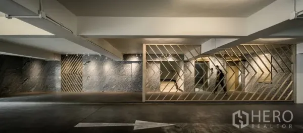 Office Space for rent in Bang Kapi, Bangkok - Basement parking area with diagonal metal screens and a painted directional arrow.