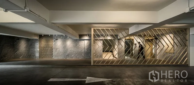 Office Space for rent in Bang Kapi, Bangkok - Basement parking area with diagonal metal screens and a painted directional arrow.