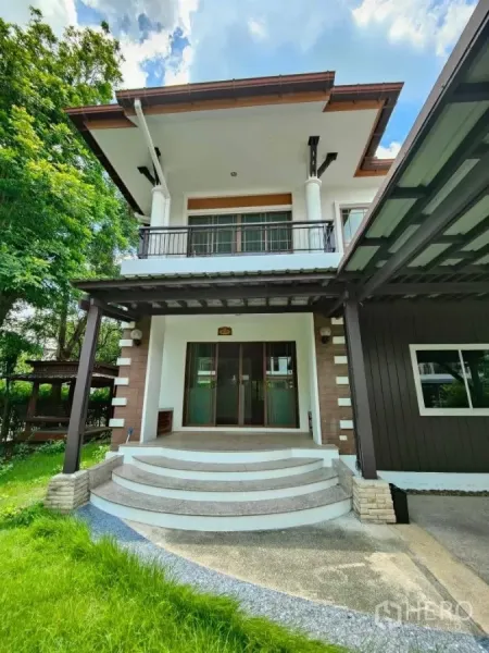 独立式住宅 出租或出售在Mueang Nonthaburi, Nonthaburi - 弧形台阶通往正门，上方有阳台，前院景观整洁。