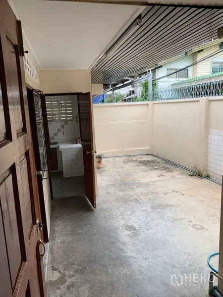 联排别墅 出租在Watthana, Bangkok - 后方服务庭院，水泥地面与高隐私围墙，连接厨房。