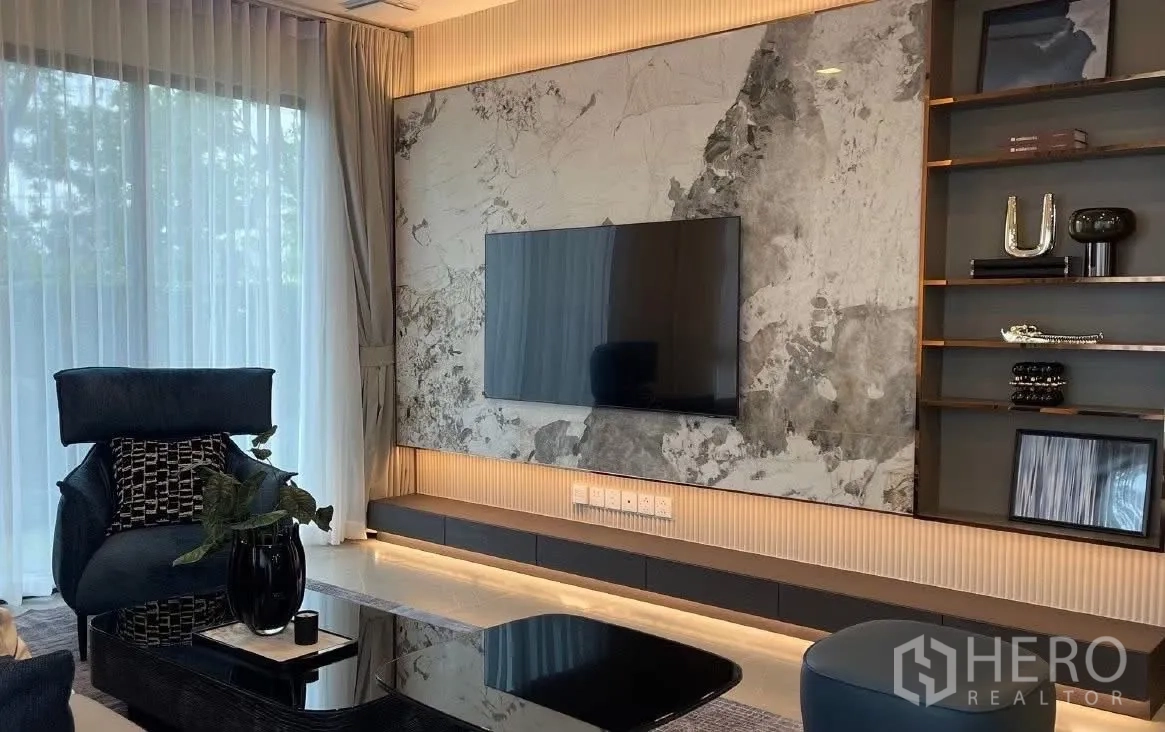 Detached House for rent in Bang Phli, Samut Prakan - TV wall with large screen, marble paneling, and display shelves.