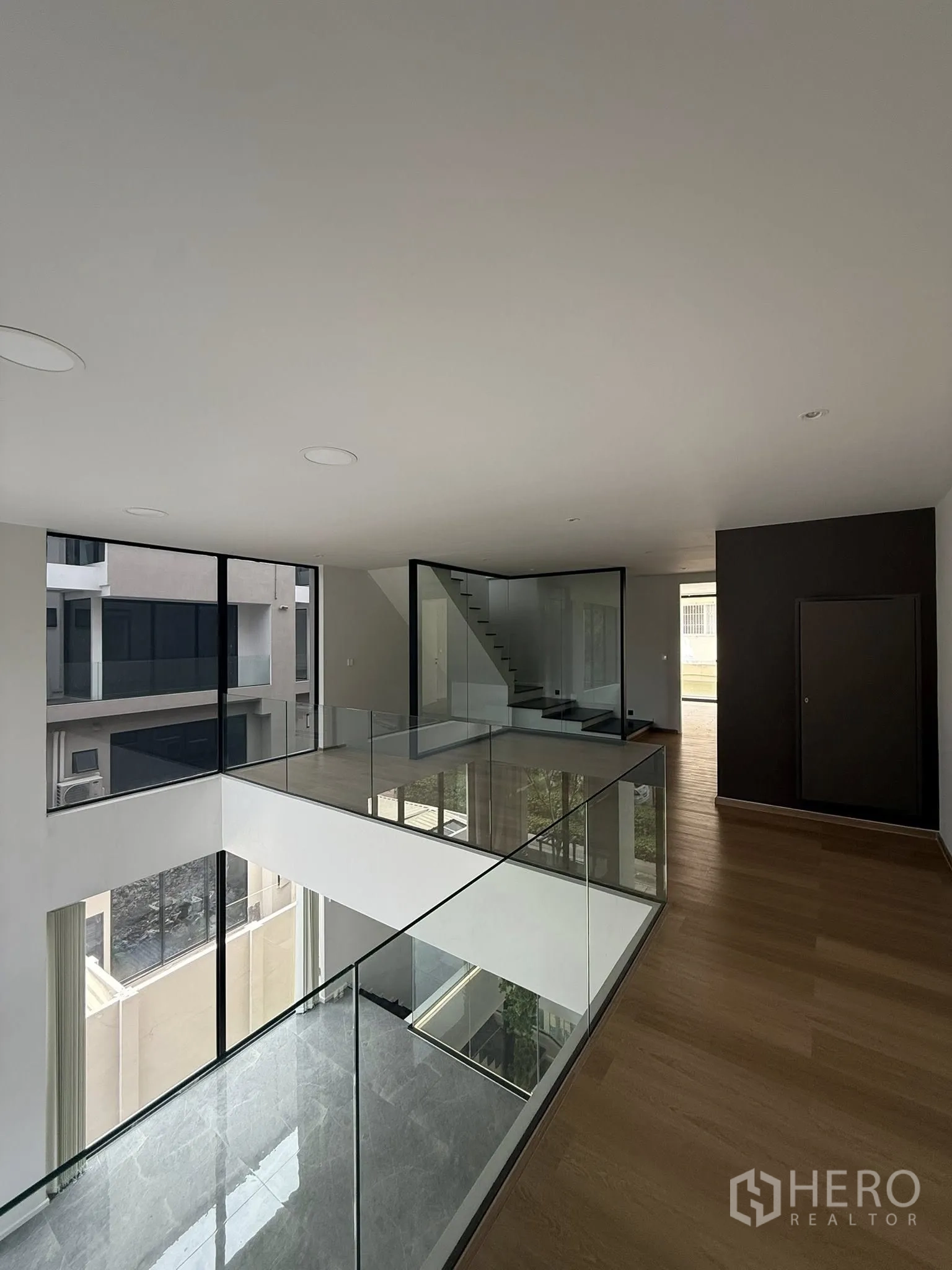 สำนักงานที่บ้าน ให้เช่าหรือขายในLat Phrao, Bangkok - ทางเดินชั้นบนราวกระจกรอบโถงกลางและบันได.