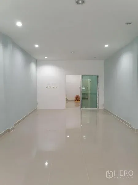 Shophouse for rent in Bang Rak, Bangkok - Bright ground-floor retail space with glossy tiled floors, recessed lighting and clean white walls.