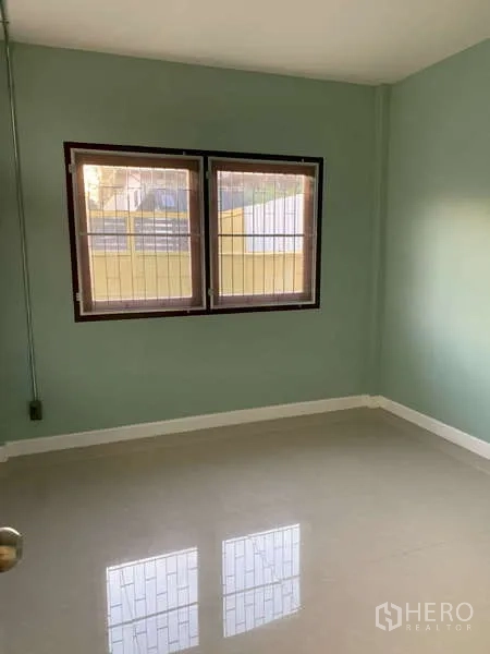 独立式住宅 出租或出售在Phra Khanong, Bangkok - 一层小房，亮面瓷砖地面与带防盗栏的双窗。