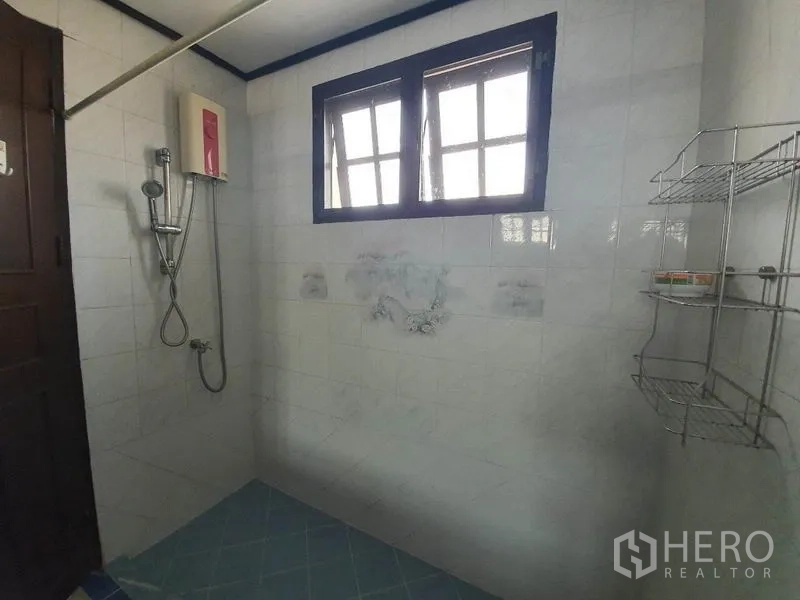Detached House for rent - Tiled bathroom featuring a walk-in shower with water heater and wall shelves.