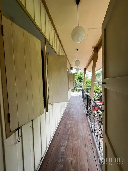 ทาวน์เฮาส์ ให้เช่า - ระเบียงไม้ยาวแบบมีหลังคา ราวเหล็ก และโคมไฟทรงกลม