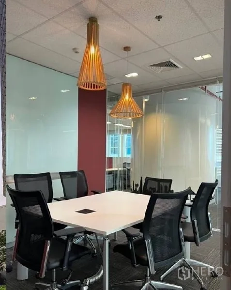 Office Space for rent - Glass-walled meeting room with a square table, six mesh chairs and warm pendant lighting in a Bangkok office.