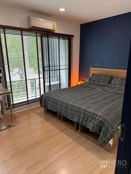 ทาวน์เฮาส์ ขายในWang Thonglang, Bangkok - ห้องนอนสว่างพร้อมประตูกระจกออกระเบียง พื้นไม้ และเตียงควีน