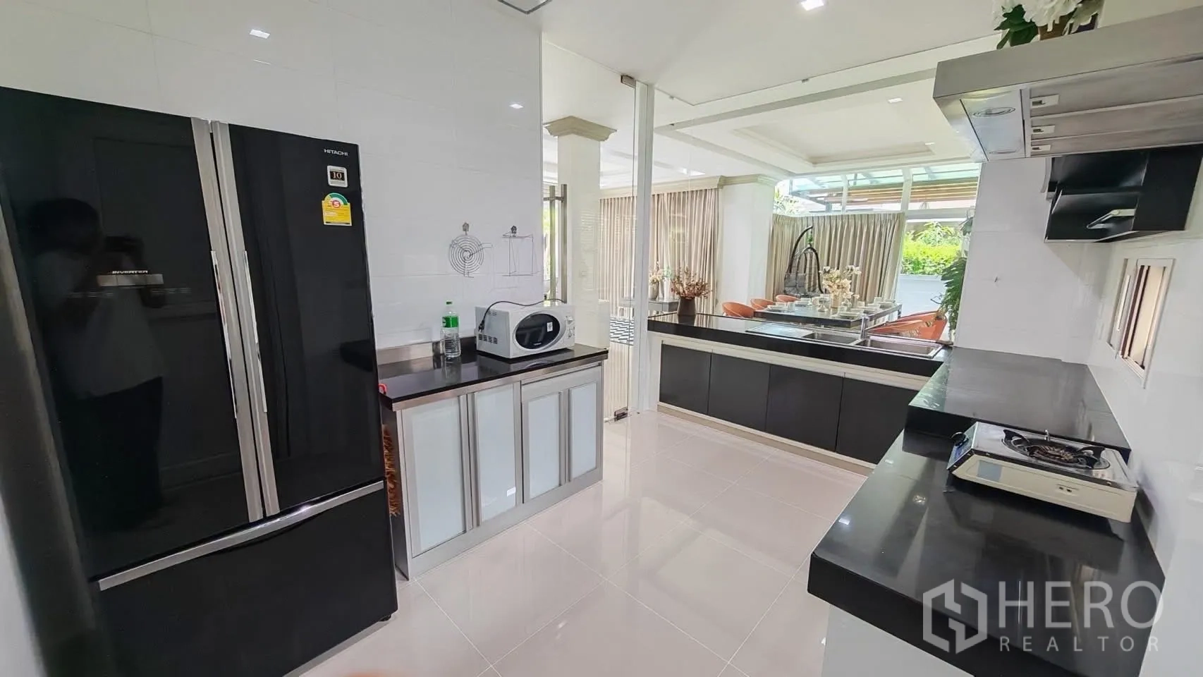 Detached House for rent or sale in Bang Phli, Samut Prakan - Kitchen opening toward the dining area with a large fridge and peninsula counter.