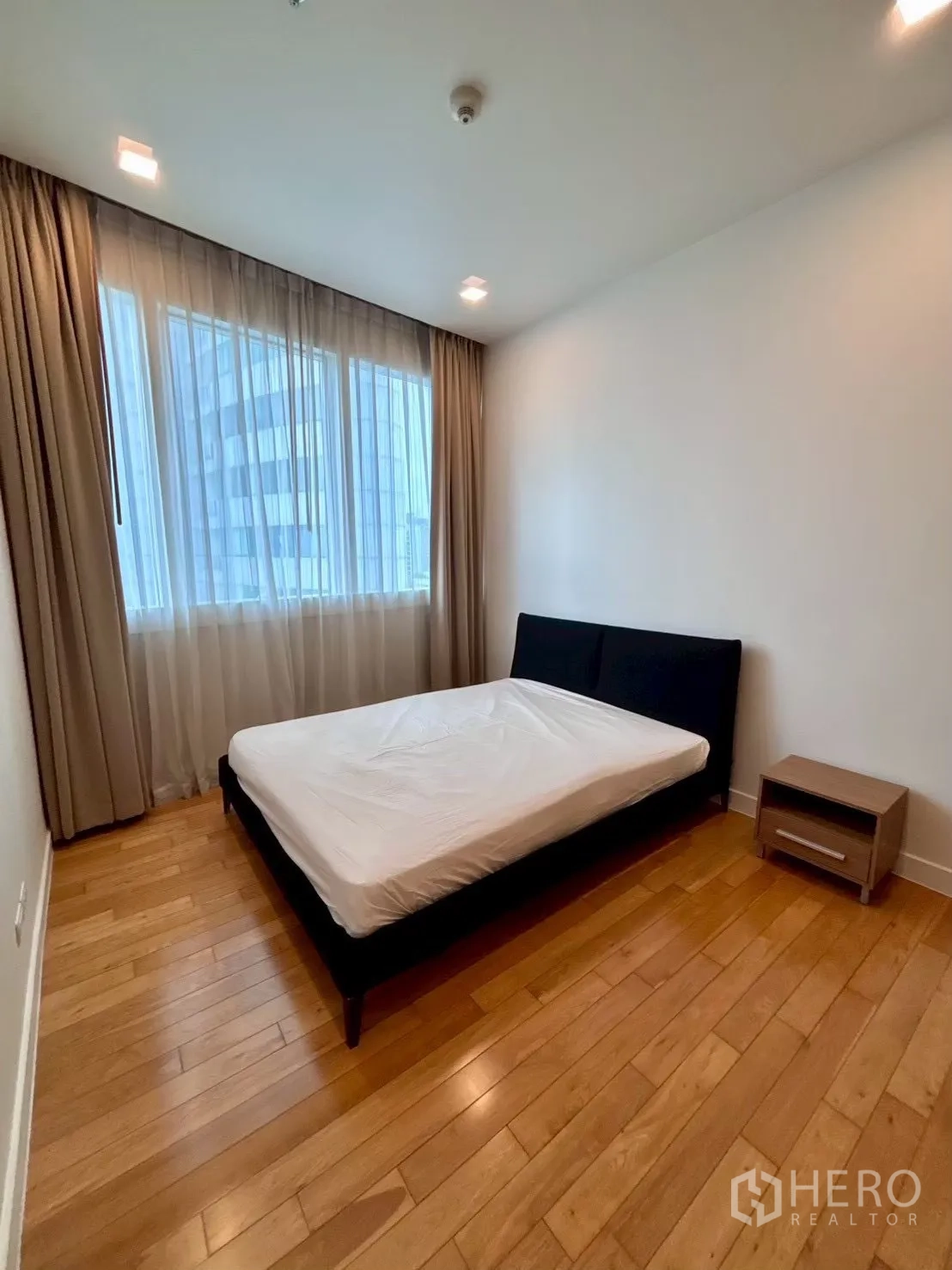 Condominium for rent in Khlong Toei, Bangkok - Bedroom with double bed, large window and sheer curtains