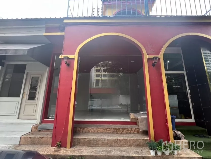 Retail Space for rent in Watthana, Bangkok - Glass-front retail storefront with red-and-gold arched facade and entry steps.
